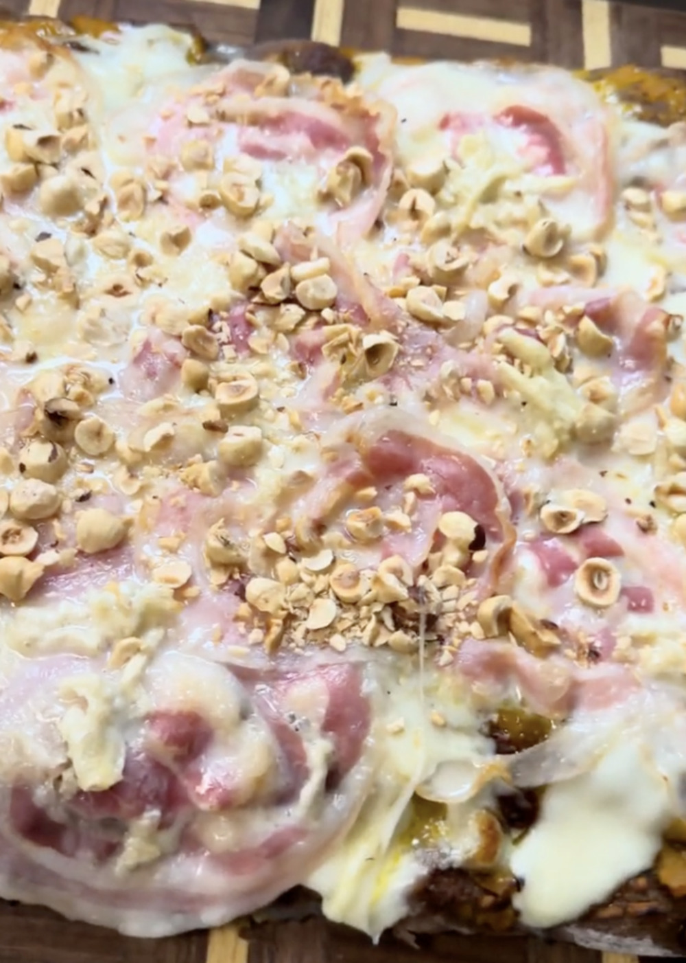 Pan pizza with cocoa dough, pumpkin cream, crispy bacon, IGOR sweet Gorgonzola and toasted hazelnuts
