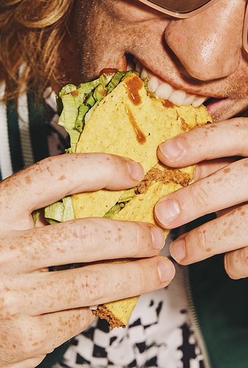 Limmagine mostra una persona che gusta un panino con formaggio Gorgonzola IGOR, simbolo di qualità e sapore autentico dellItalia.