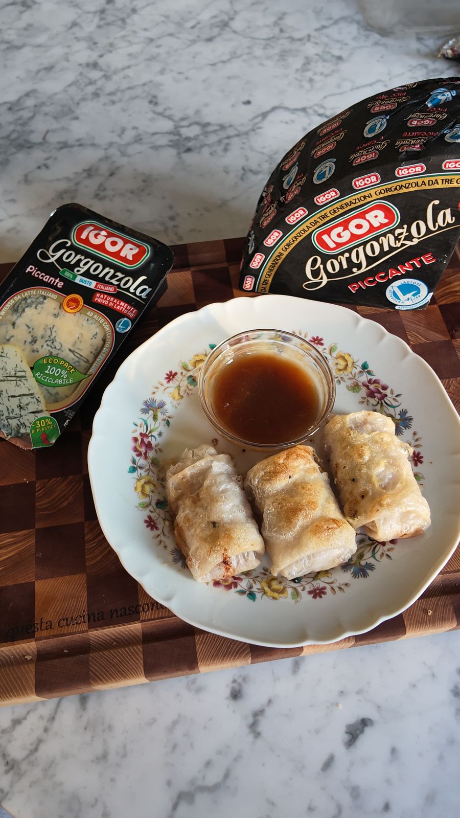 Immagine di formaggi Gorgonzola IGOR, involtini di carta di riso con Gorgonzola Piccante, e una salsa, rappresentando il legame tra formaggi italiani e sport.