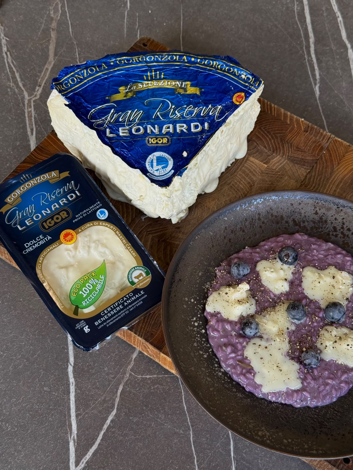 Immagine di formaggio Gorgonzola IGOR e un piatto di risotto con gorgonzola e uva fragola, simbolo di qualità italiana, dairy e sponsorizzazione di volley.